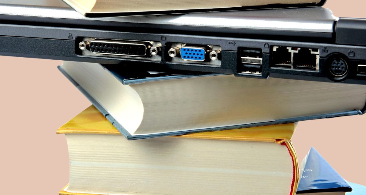 Ein Stapel aus Büchern und einem Laptop.